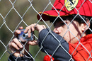 A Ferrari fan snaps the action through the fence
