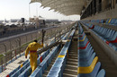 A worker cleans seats ahead of a grand prix that might not happen in Bahrain
