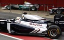 Pastor Maldonado leaves the pits past a spare Mercedes