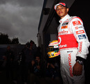 Lewis Hamilton poses for a photo in the paddock