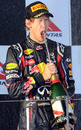 A face full of champagne for Sebastian Vettel as he leads the podium celebrations