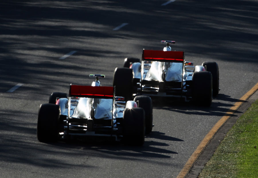 The McLarens of Jenson Button and Lewis Hamilton run nose-to-tail out of turn two