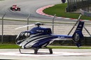 Timo Glock passes a parked helicopter during Friday practice