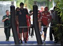 Fernando Alonso jumps the gates as he enters the paddock with Mark Webber