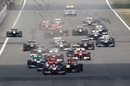 Jenson Button leads away as Lewis Hamilton pressures Sebastian Vettel