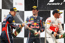 The Red Bull drivers and Lewis Hamilton spray champagne on the podium