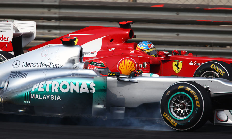 Michael Schumacher locks a wheel as he defends from Fernando Alonso