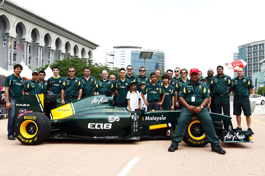 Tony Fernandes poses for photos with the rest of the Lotus team