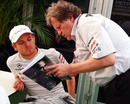 Norbert Haug and Nico Rosberg look over some notes