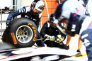 Williams mechanics practise putting wet tyres on the FW33 in the pit lane