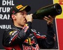 Sebastian Vettel takes a swig of champagne on the podium