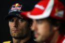 Mark Webber listens to Fernando Alonso during the press conference